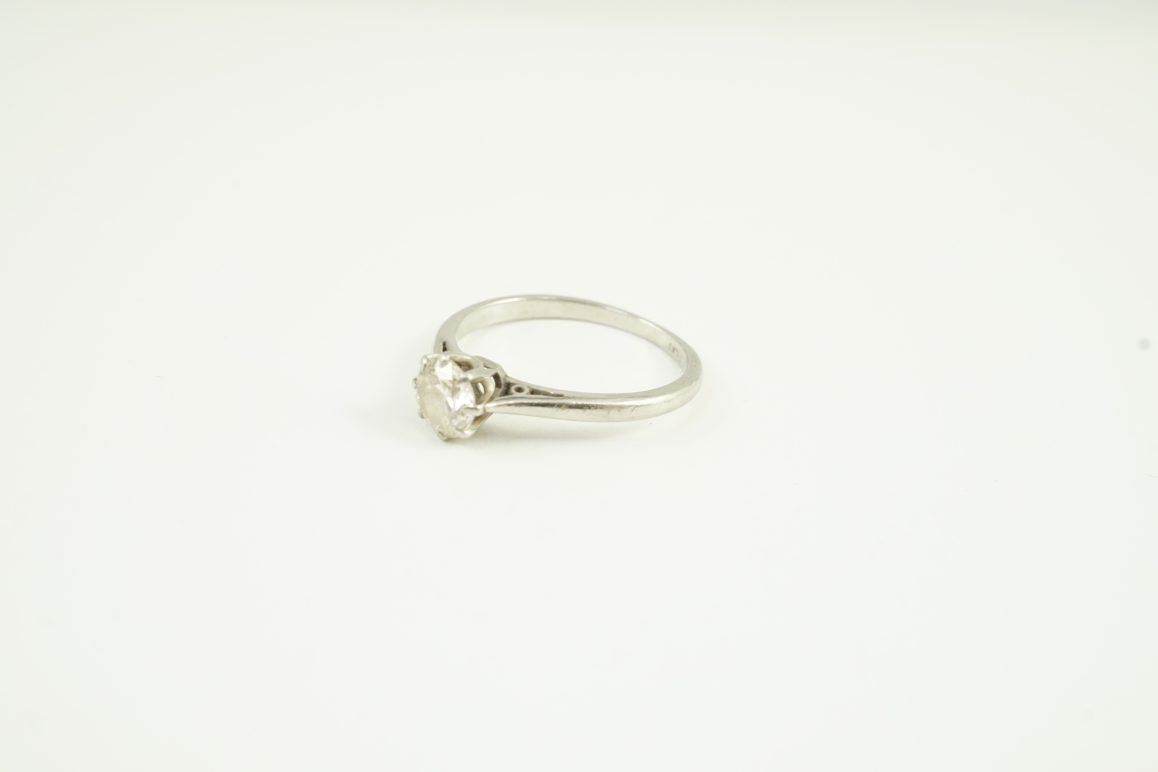 A white metal (stamped plat) and solitaire diamond set ring, size K, gross weight 2.6 grams